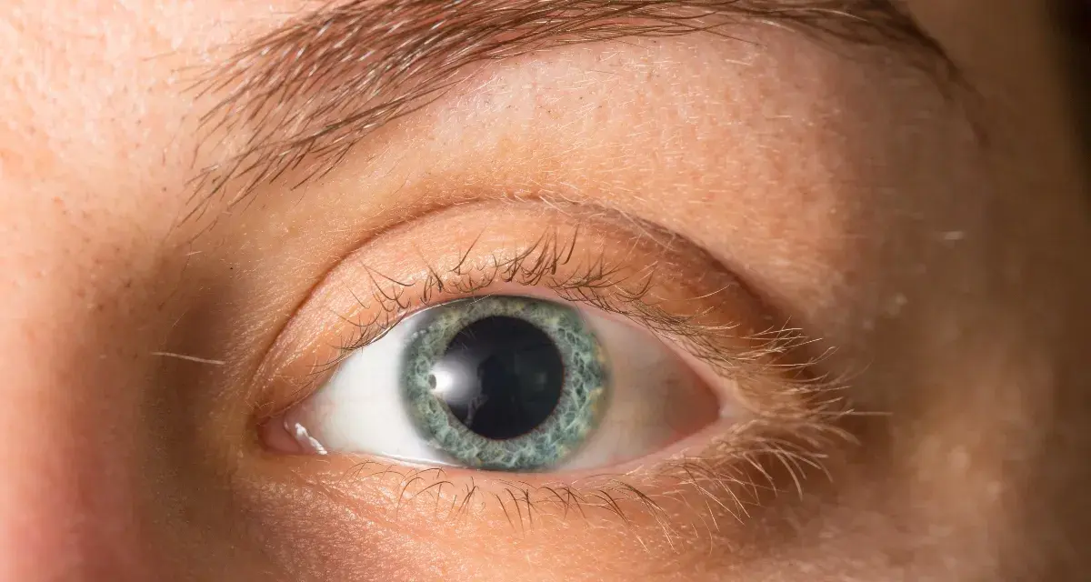 Occhio con iride azzurra e pupille dilatate, forse per l'emozione o la poca luce.