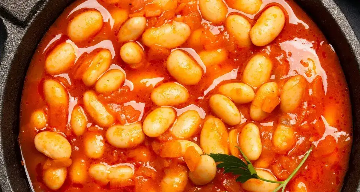 Pyszna fasolka po bretońsku przepis w garnku. Aromatyczne danie z białej fasoli w sosie pomidorowym, ozdobione natką pietruszki.