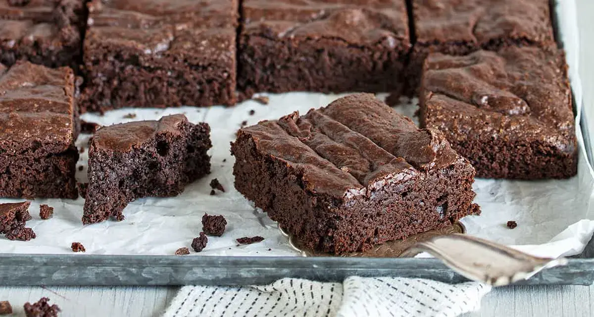 Saftige Schokoladen-Brownies, perfekt für jedes Brownie Rezept. Ein Stück wird gerade herausgehoben.