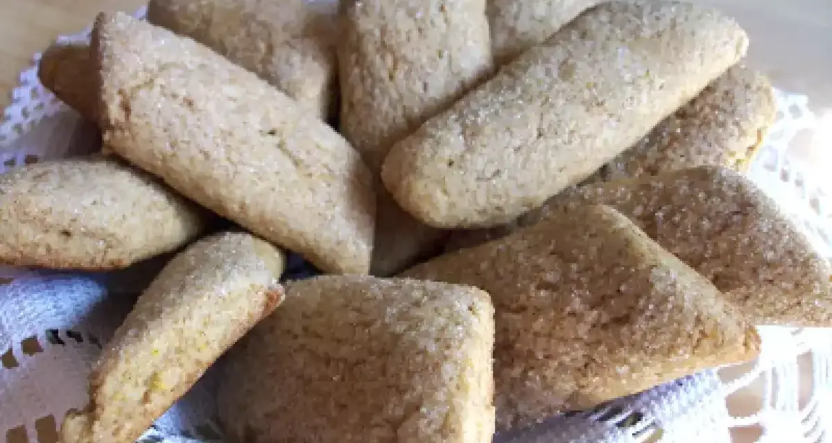 Un cesto pieno di biscotti della nonna, dorati e cosparsi di zucchero, invitano a un assaggio di dolcezza casalinga.