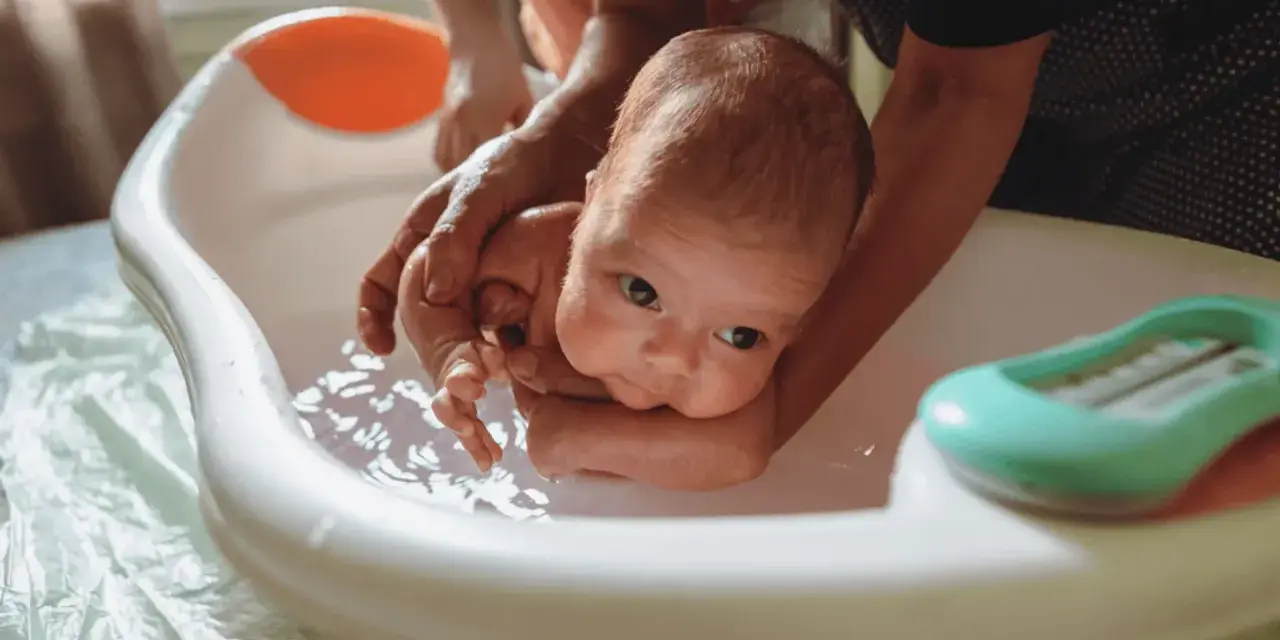 Delikatne kąpiel noworodka w wanience. Czy przy gorączce można kąpać dziecko? Tak, ale w letniej wodzie.