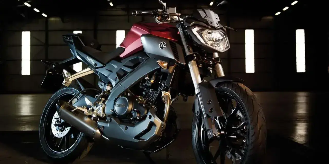 Czerwono-szary motocykl Yamaha TZR 125 V-Max w ciemnym pomieszczeniu.