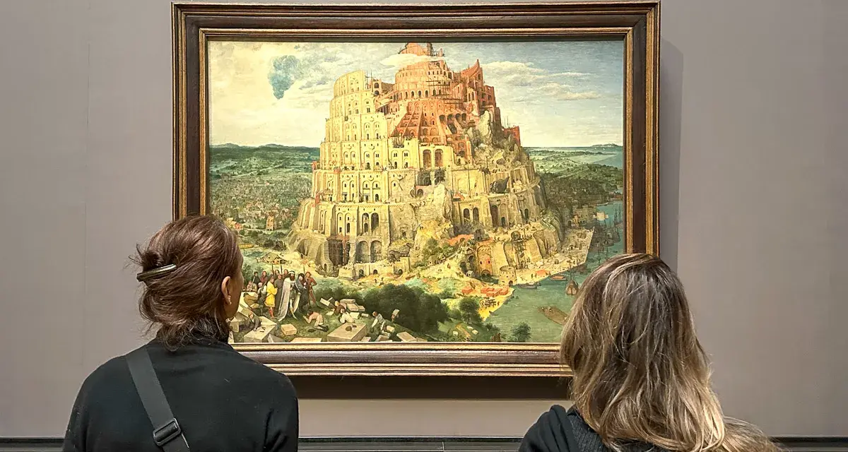 Dwie osoby oglądają obraz Wieża Babel w Muzeum Historii Sztuki w Wiedniu.