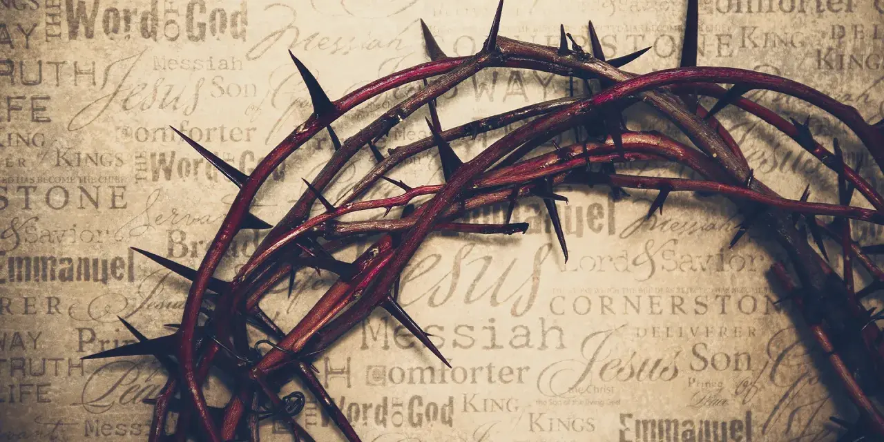 Dornenkrone auf Pergament mit Titeln wie "Jesus", "Messiah", "Savior". Sie symbolisiert die tiefe Jesus Christus Bedeutung und sein Leiden.