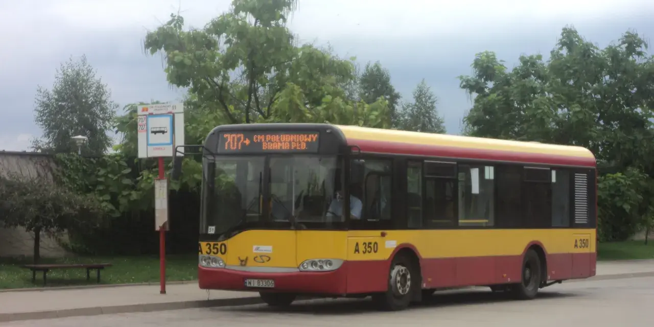 Autobus 707 z napisem "CM. POŁUDNIOWY BRAMA PŁD." czeka na pasażerów. Rozkład jazdy jest widoczny na przystanku.