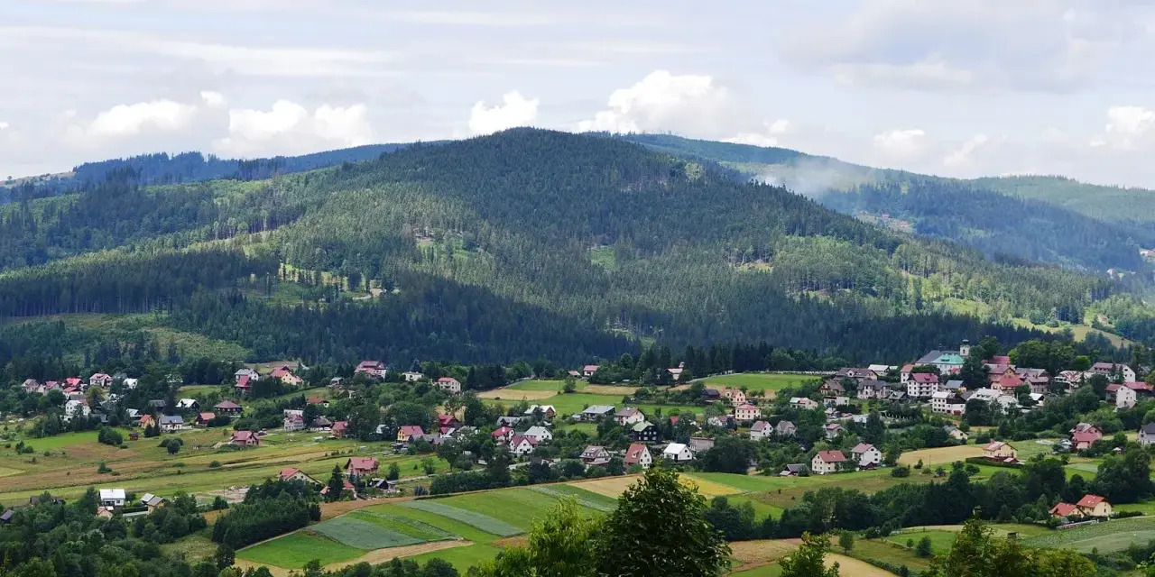 Letnia panorama Istebnej z górami i domkami. Idealne miejsce na wakacje, pełne atrakcji.