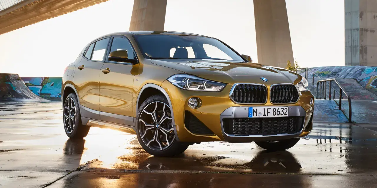Złoty BMW X2 na tle mostu i skateparku. Nowoczesny leasing jak abonament, bez zobowiązań.