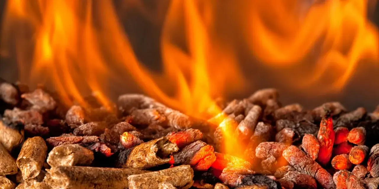 Fiamme arancioni danzano su un letto di pellet ardente. Per scaldare 100 mq, quanti kw servono?