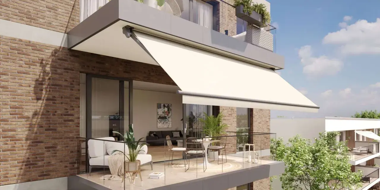 Balcón moderno con sofá, mesa y sillas, protegido por uno de los tipos de toldos más elegantes.