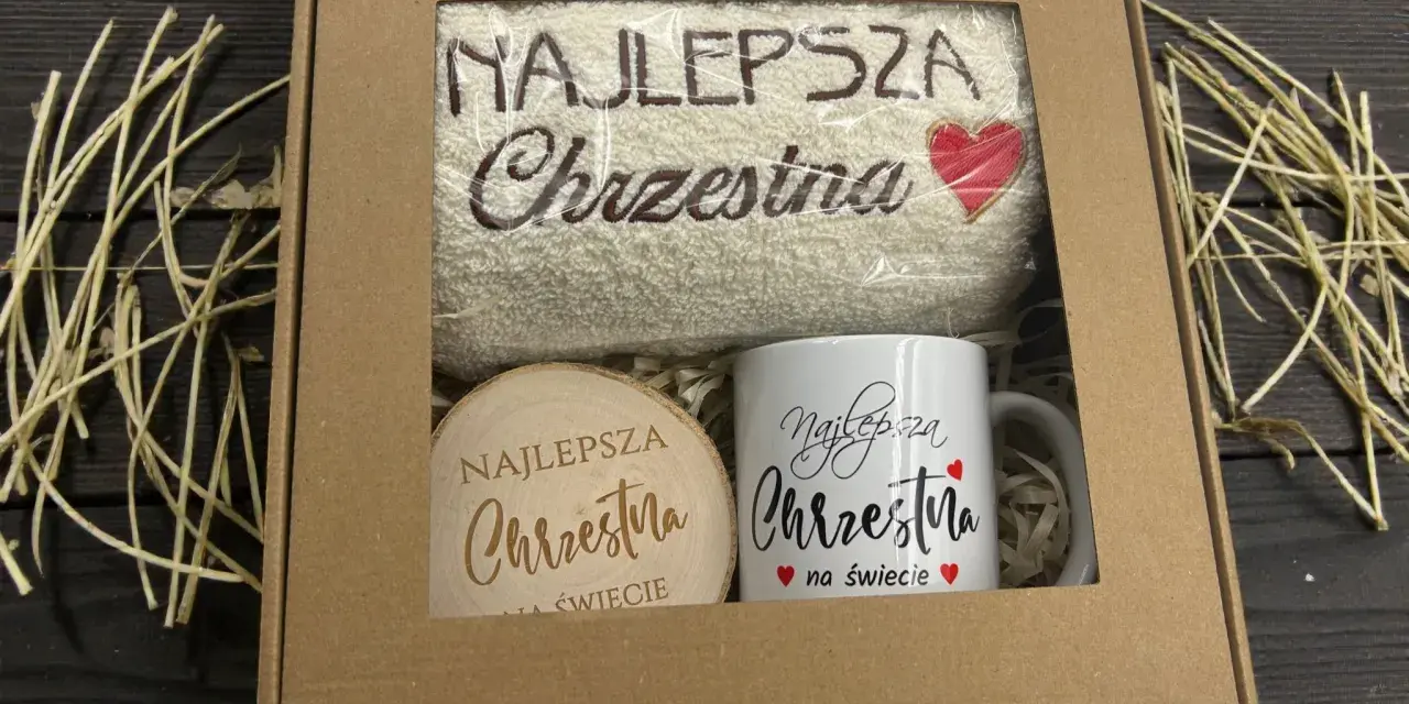 Prezent dla najlepszej chrzestnej: ręcznik z haftem i kubek z napisem "Najlepsza Chrzestna na świecie".