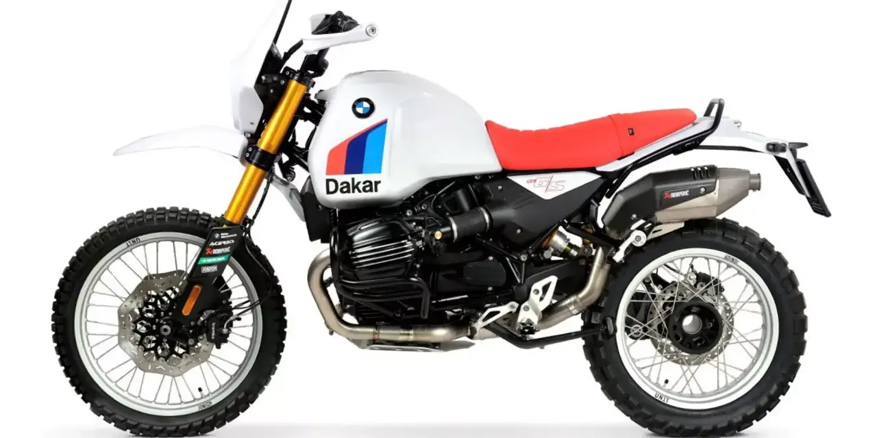 Biały motocykl BMW R 12 z czerwonym siedzeniem i grafiką "Dakar" na zbiorniku paliwa, gotowy na przygodę.