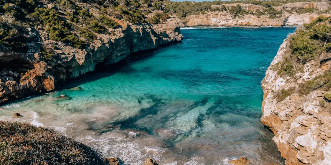 Cala des Moro, Majorka. Turkusowa woda obmywa skaliste wybrzeże, tworząc malowniczą zatoczkę.