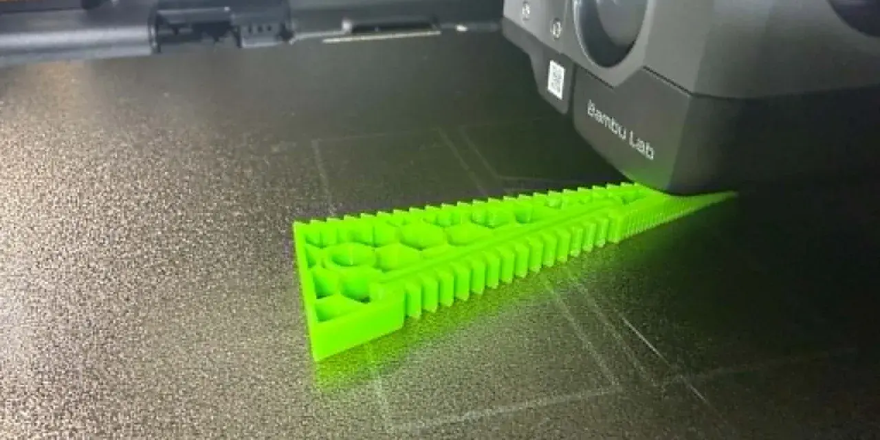 Drukarka 3D tworzy zielony obiekt z filamentu TPU, pokazując jego elastyczne właściwości.