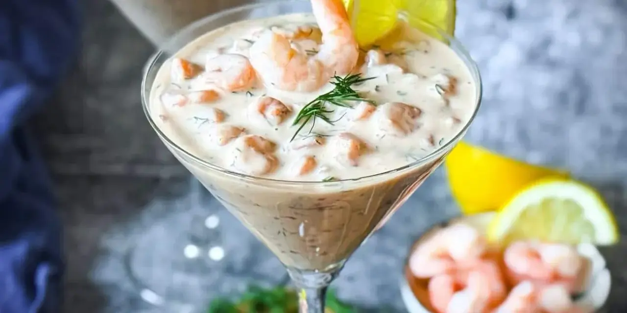 Ein cremiger Shrimp Cocktail in einem Martiniglas, garniert mit Dill und Zitrone. Ein köstlicher Genuss!
