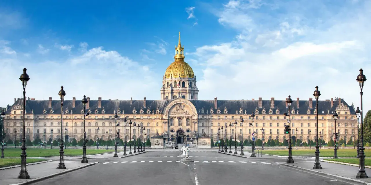 Imponente cúpula dorada del Hôtel des Invalides en París, con su fachada clásica y farolas a ambos lados de la avenida.
