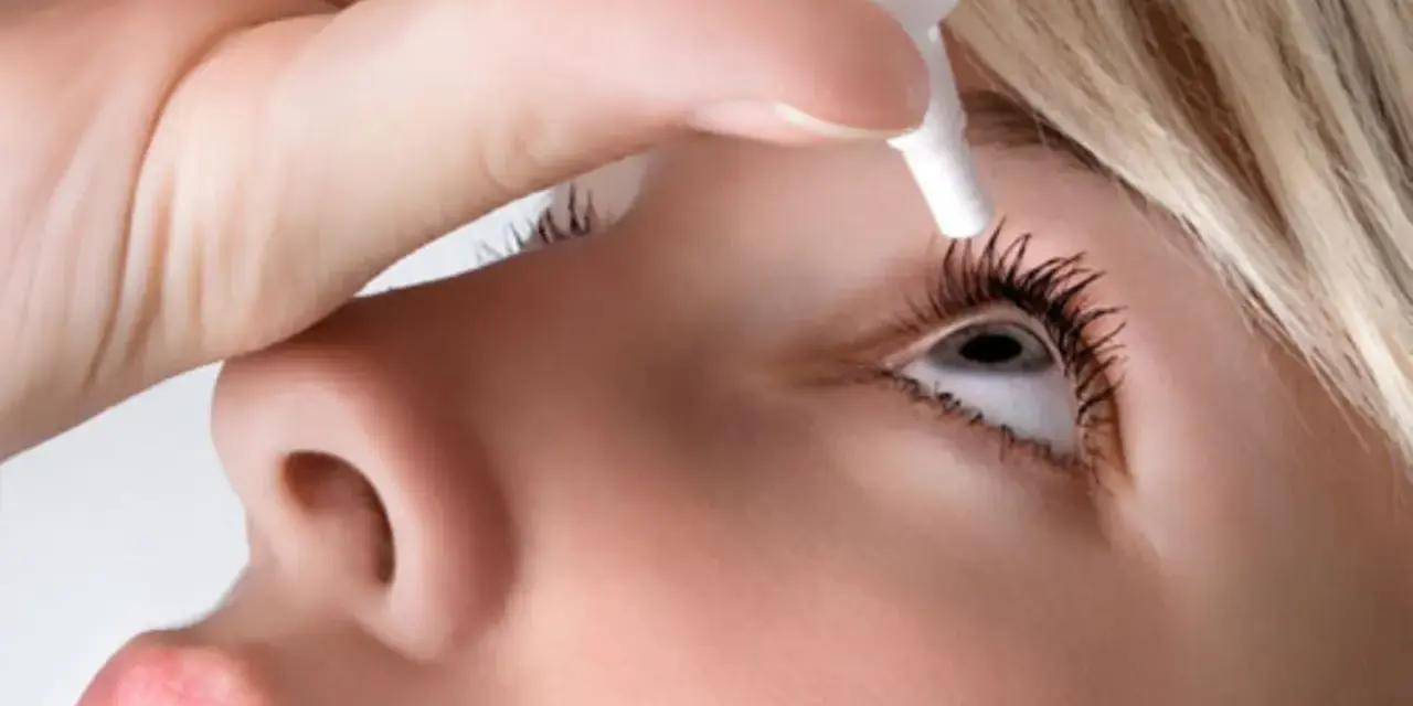 Persona applica collirio per trattare l'edema corneale post cataratta, alleviando i sintomi.