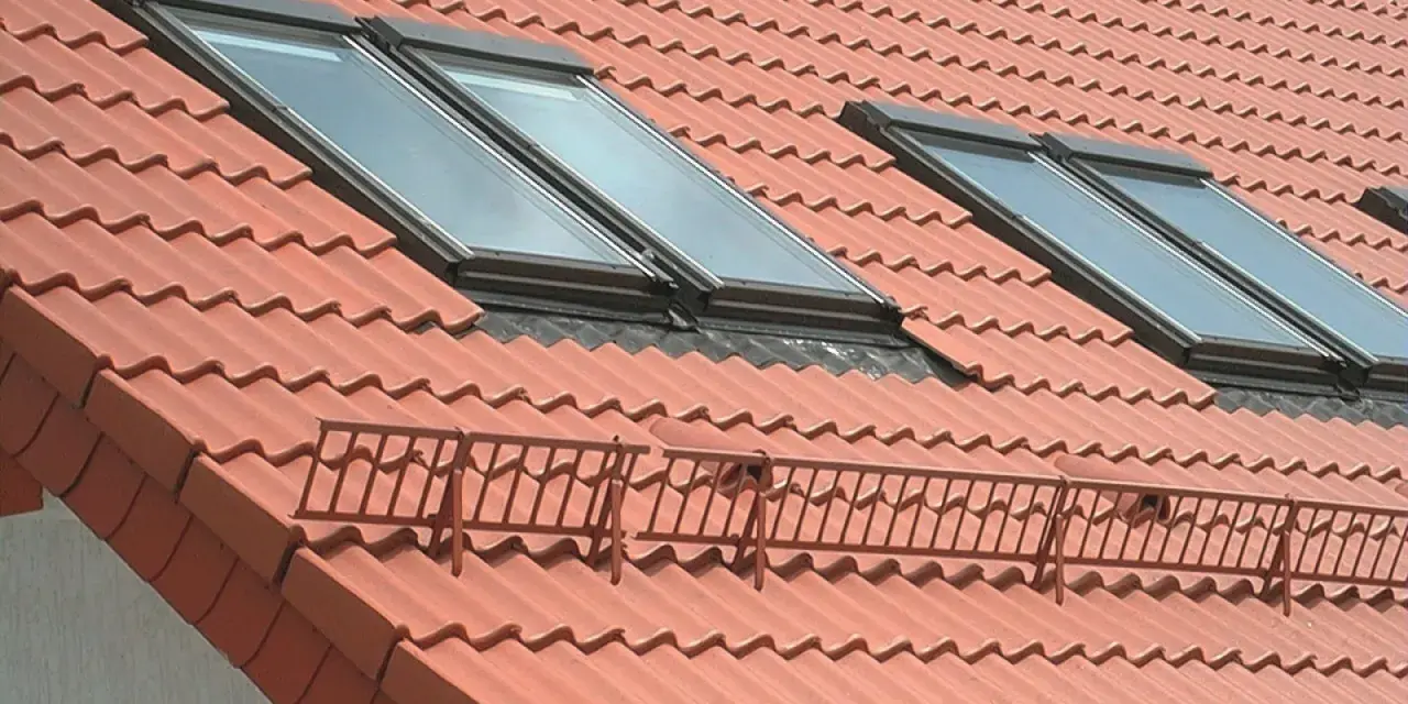 Nowy dach z dachówką ceramiczną, orynnowanie i okna dachowe zapewniające światło.