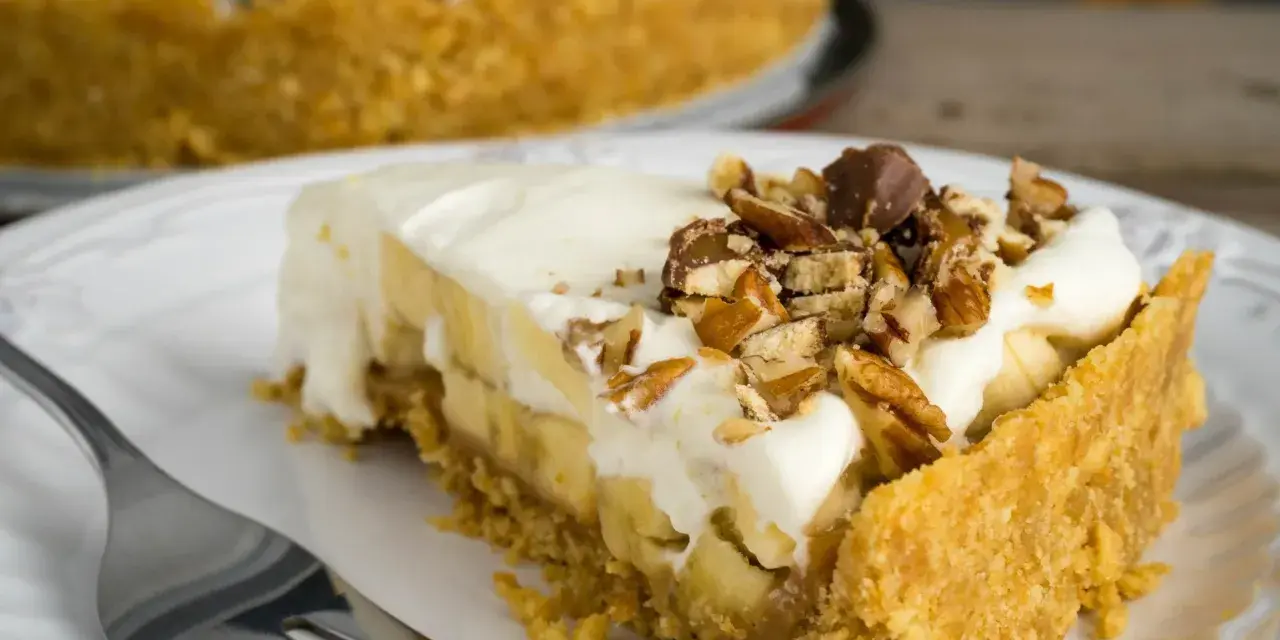 Pyszny kawałek Banoffee Pie z bananami, kremem i orzechami. Idealny na deser, gdy masz ochotę na coś słodkiego.