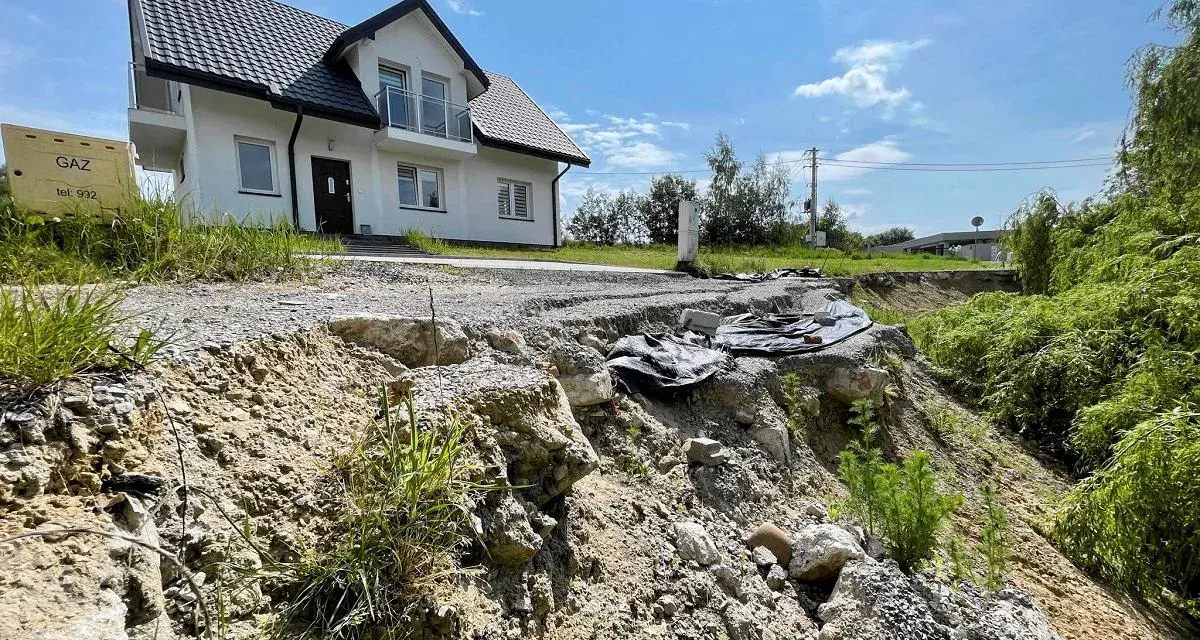 Nieaktywne osuwisko obok budowy domu. Teren niestabilny, droga częściowo zniszczona.