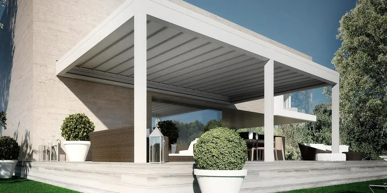 Pergolato fai da te economico, moderno e funzionale, con arredi da esterno e piante in vaso su una terrazza in pietra.