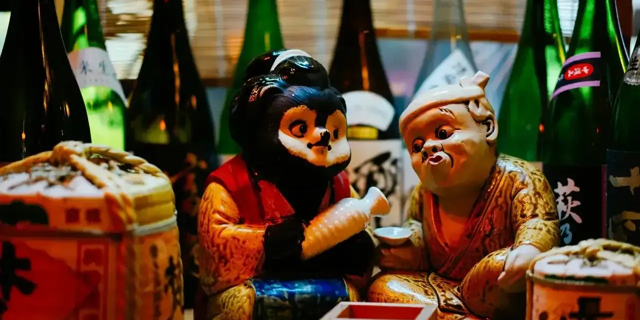 Figurki tanuki i starca z sake. Dowiedz się, jak pić sake, by poczuć japoński klimat.