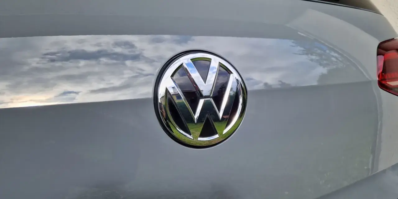 Das VW-Logo auf dem Heck eines grauen Autos. Eine Erklärung zum Fahrzeugdatenträger VW ist hier nicht ersichtlich.