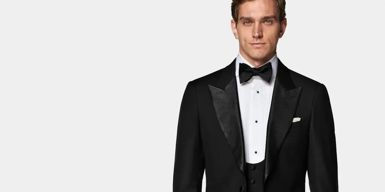Elegancki mężczyzna w czarnym smokingu, idealny na wydarzenia z kodem **black tie dress code**.