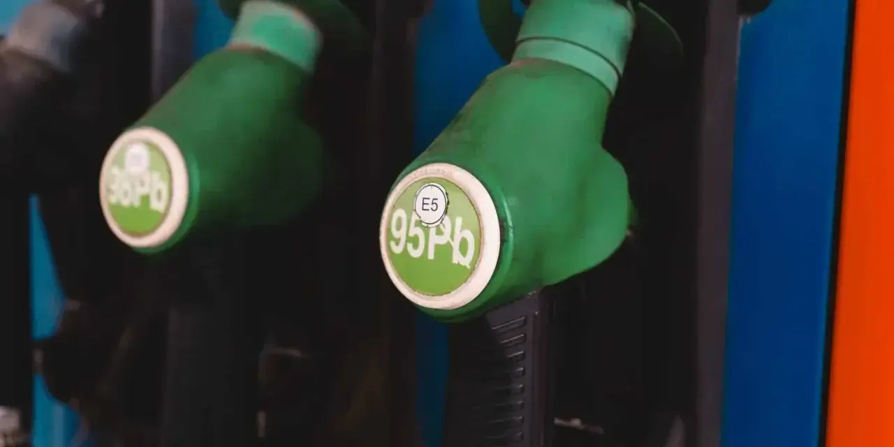 Dwa zielone pistolety dystrybutorów paliwa, jeden z napisem "98 Pb", drugi z "E5 95 Pb". Idealne do tankowania VW Polo 1.2 benzyna.