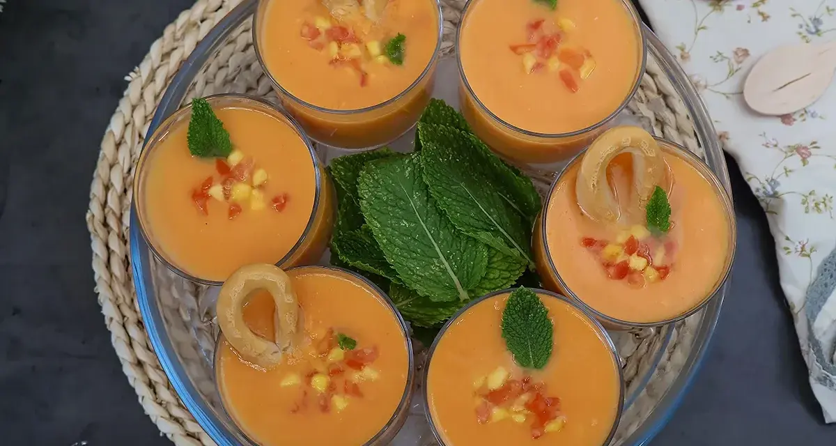 Gazpacho de mango en vasos con trocitos de mango, menta y picos.
