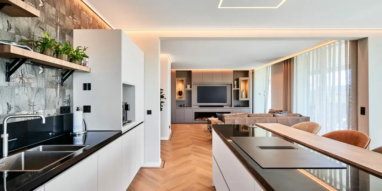 Moderne Küche mit Kochinsel und Wohnbereich. Die indirekte Beleuchtung unterstreicht die Eleganz. Informieren Sie sich über spanndecke kosten für Ihr Zuhause.