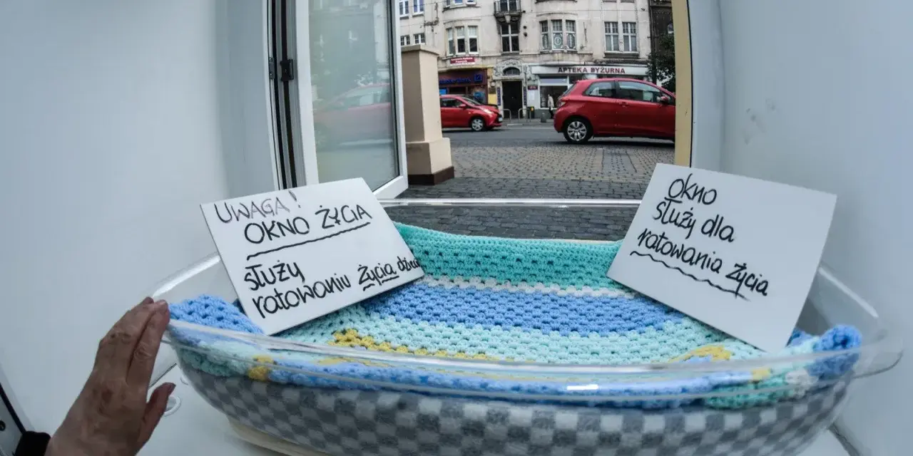 Okno życia, bezpieczne miejsce dla noworodków. Dwa napisy informują: "Uwaga! Okno życia służy ratowaniu życia dziecka" i "Okno służy dla ratowania życia".