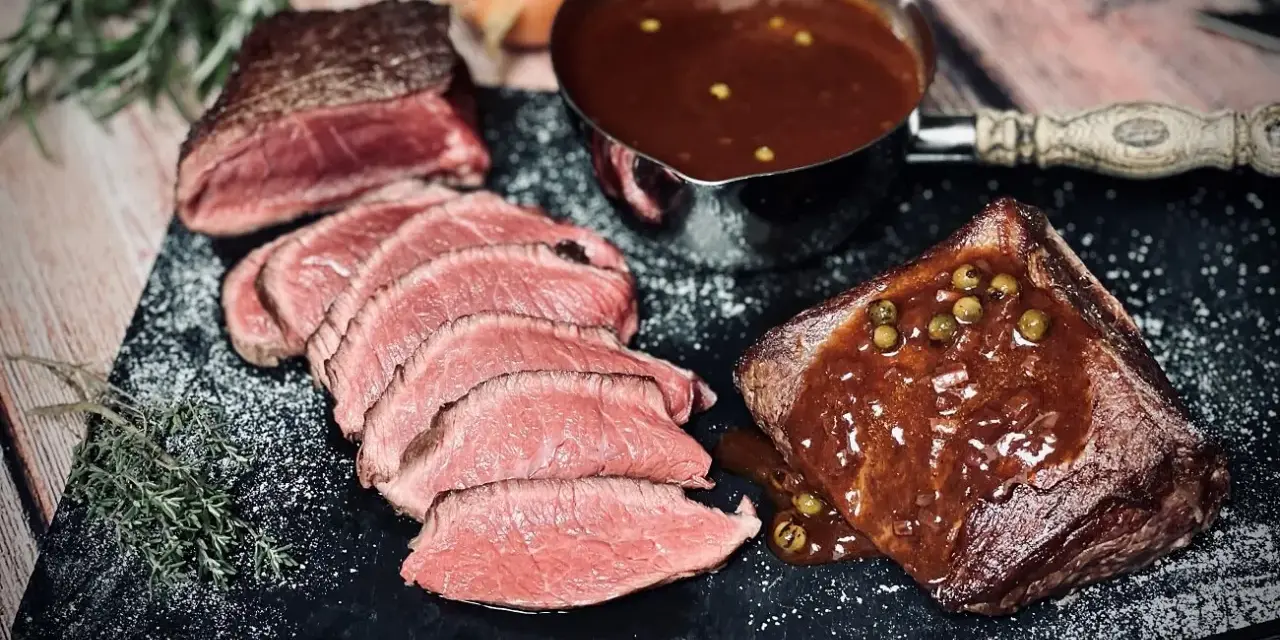 Saftiges Roastbeef mit einer cremigen Pfeffersauce, perfekt für ein festliches pfeffersauce rezept. Dazu frische Kräuter und eine Prise Salz.