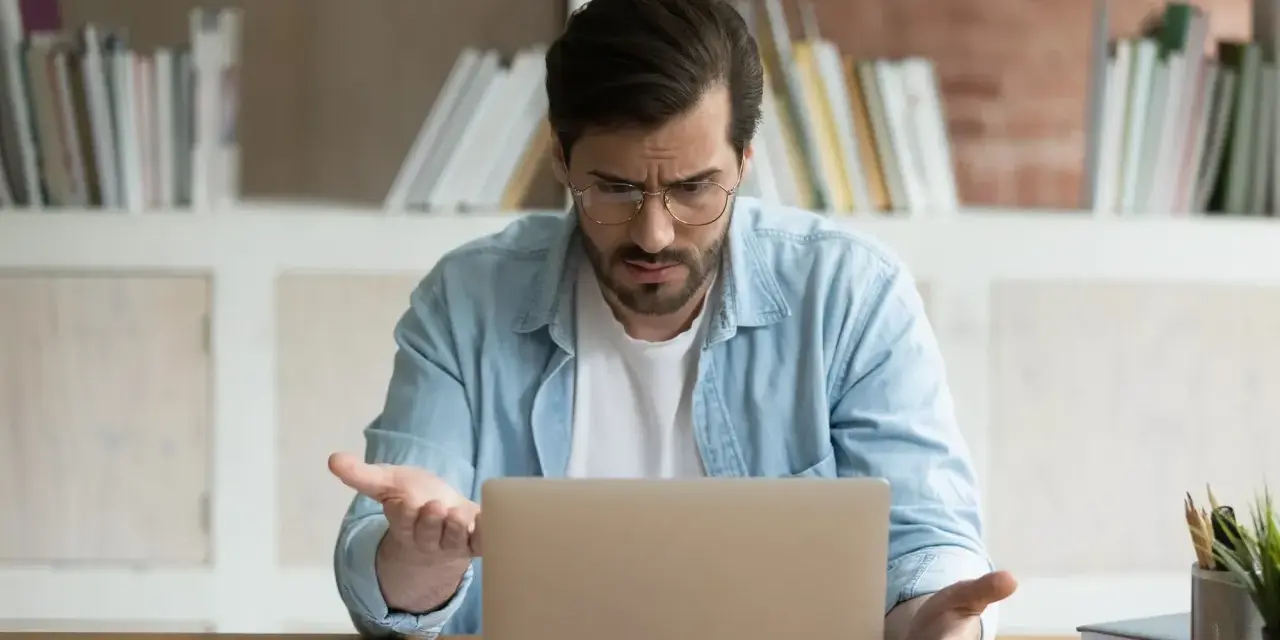Zdezorientowany mężczyzna szuka w internecie, skąd wziąć wniosek o świadczenie wspierające.