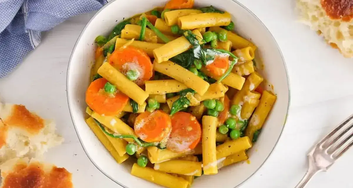 Makaron z mlekiem kokosowym i curry, z marchewką i groszkiem. Kremowy sos otula złociste rurki, tworząc aromatyczne danie.