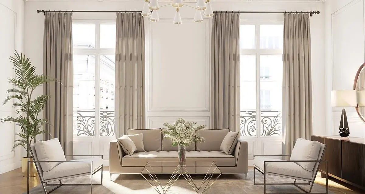 Elegancki salon w stylu klasycznym. Jasna sofa i fotele, złoty stolik kawowy, zasłony i ozdobne sztukaterie.