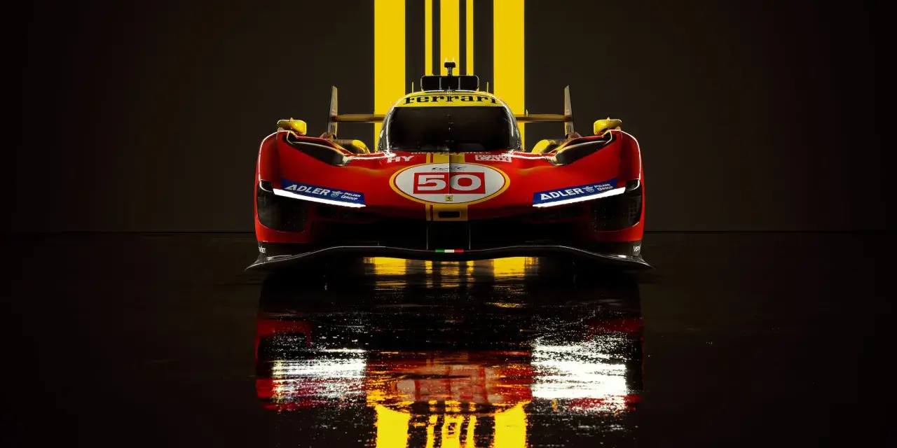 Wyścigowy Ferrari 499P w czerwono-żółtych barwach, z numerem 50, odbija się w mokrej nawierzchni.