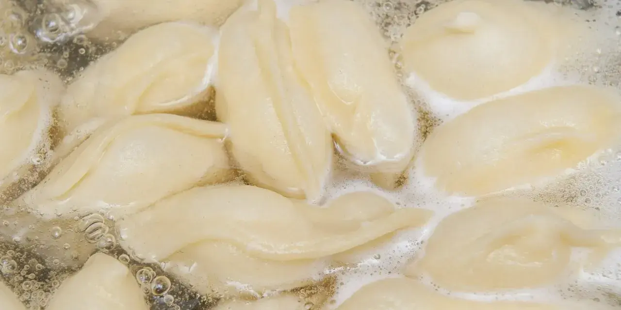 Pierogi gotujące się w bulgoczącej wodzie.