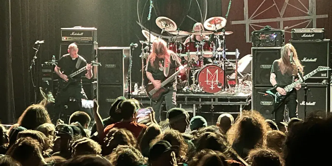 Concert de metal, musiciens sur scène, foule en délire. Le groupe semble prêt à envoyer du lourd, un vrai voyage ad patres pour les fans.