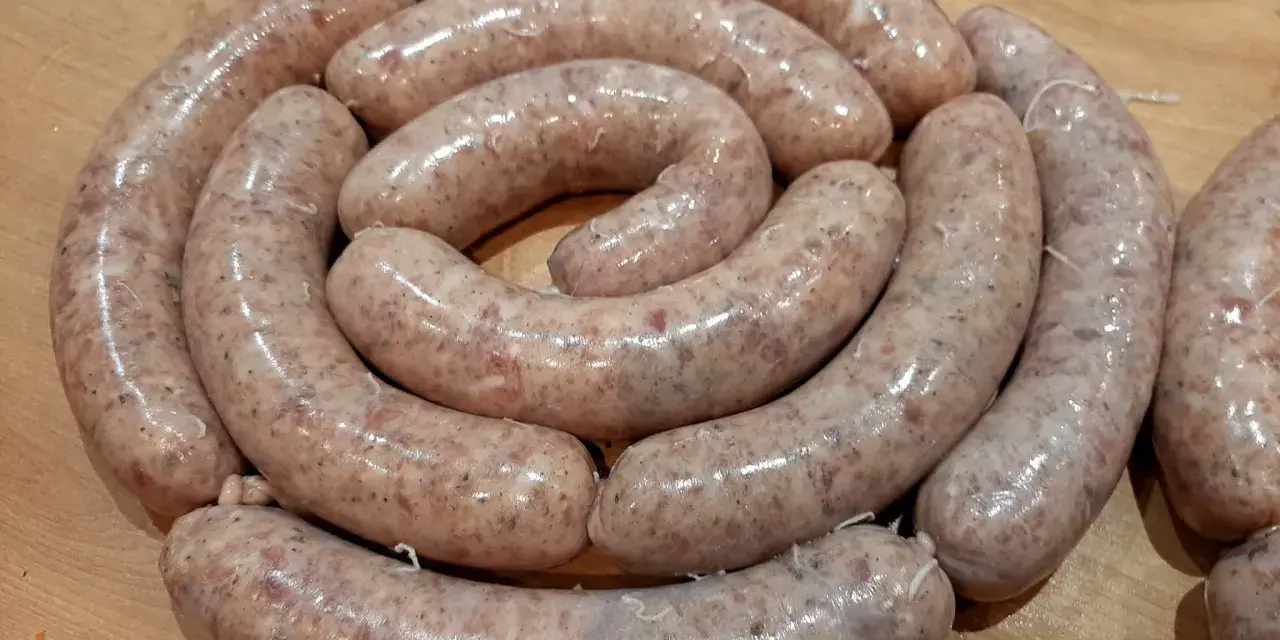 Świeża biała kiełbasa ułożona w okręgu, gotowa na przepis na 5 kg.