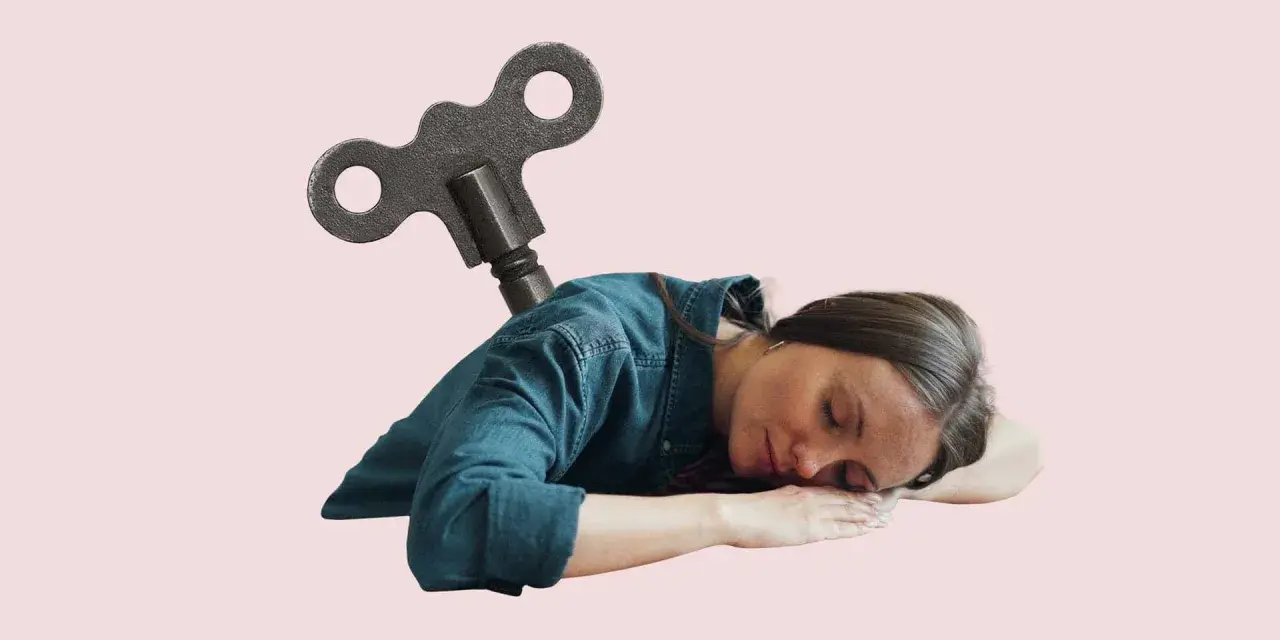 En kvinna sover med en uppdragnyckel i ryggen, som om hon är en trasig leksak. Man kan spy av stress när man är helt slutkörd.