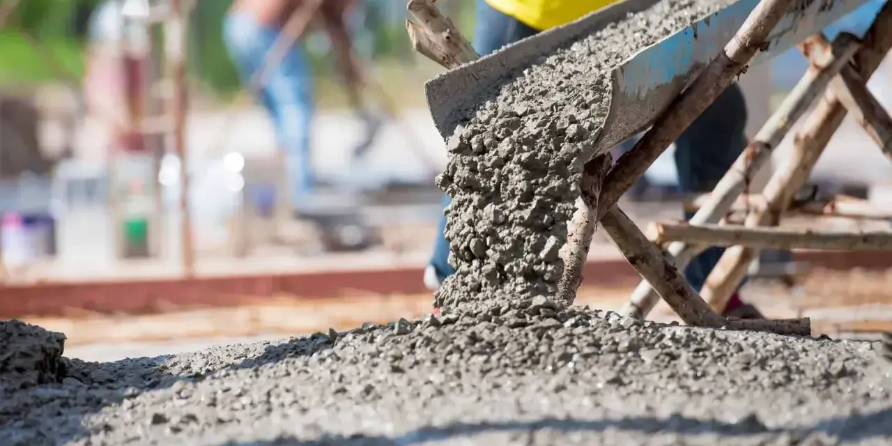 Beton wylewany z betoniarki. Pracownicy na budowie, zastanawiają się, ile cementu na kubik betonu potrzeba do wykonania solidnej konstrukcji.