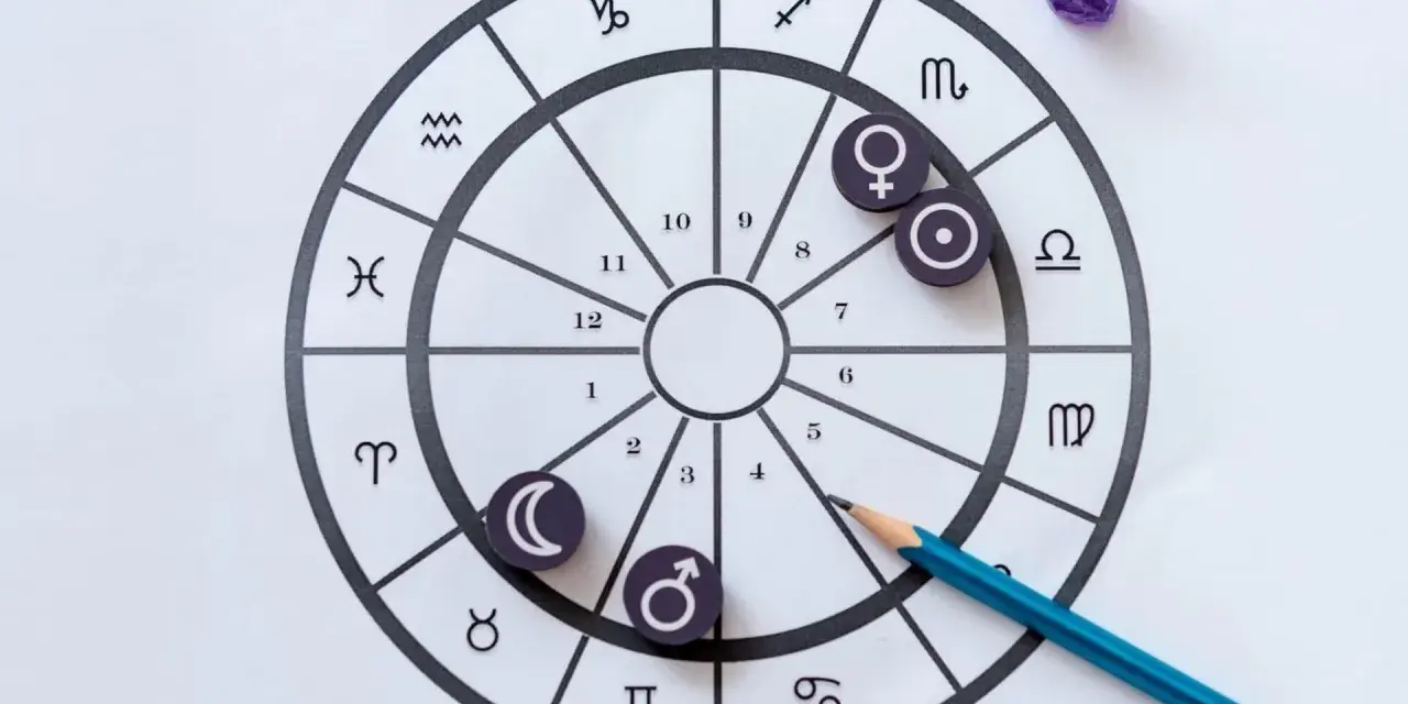 Carta astral con símbolos de planetas y signos del zodíaco, elementos de astrología. Lápiz azul sobre la rueda.