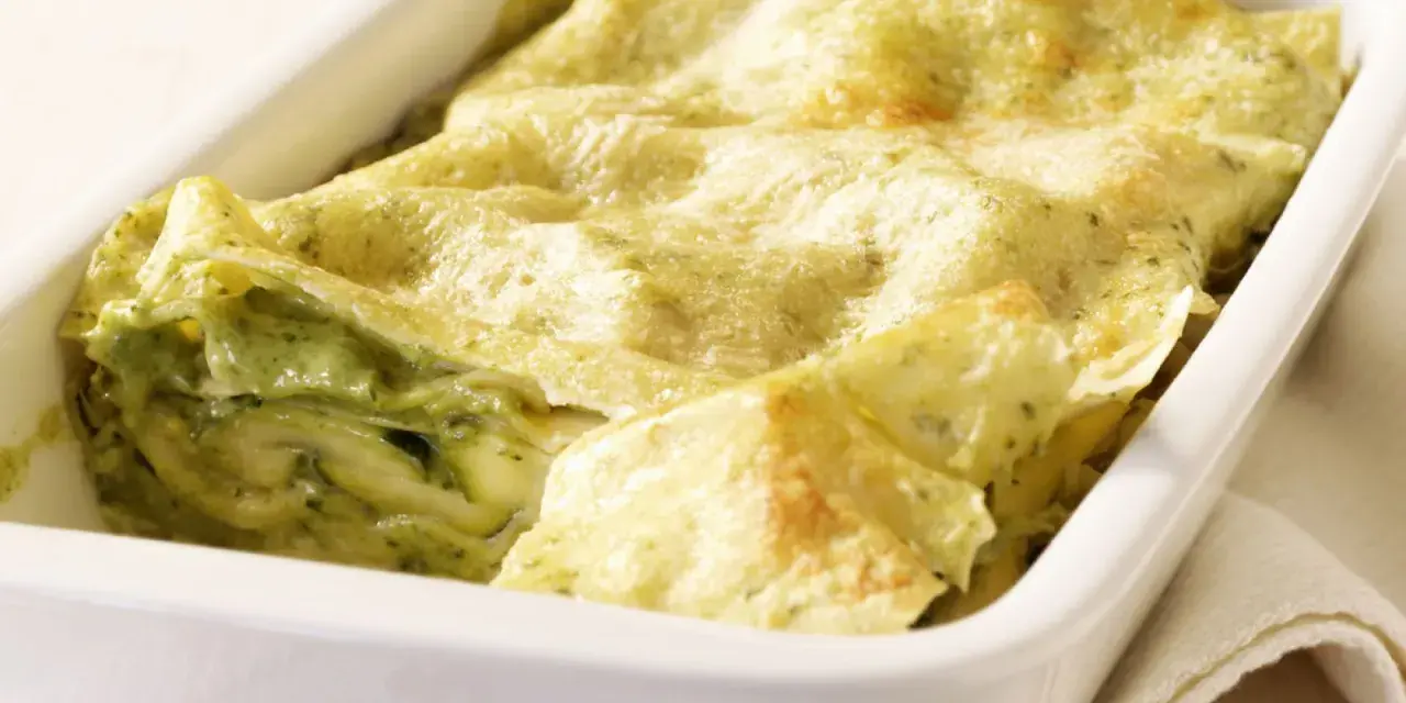 Zucchini-Lasagne mit cremiger Füllung und goldbraunen Lasagneplatten in einer weißen Auflaufform.