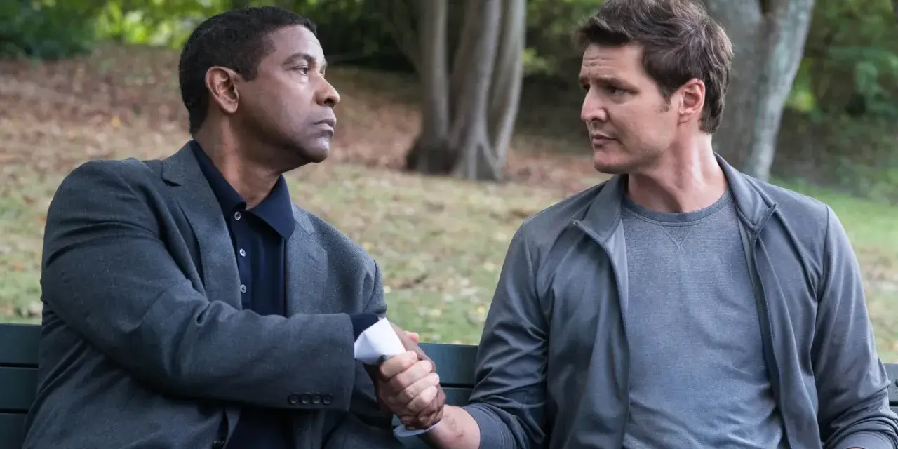 Denzel Washington i Pedro Pascal, obsada "Bez litości 2", siedzą na ławce i ściskają sobie dłonie.