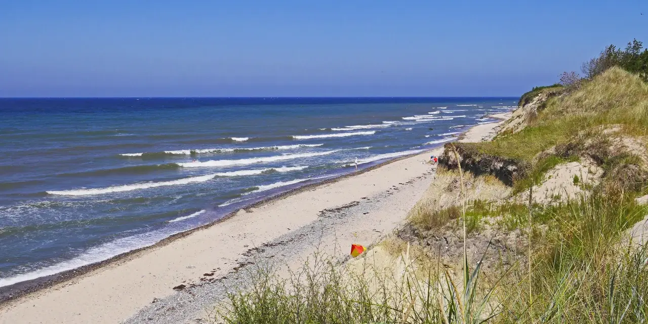 Plaża nad Bałtykiem, fale rozbijają się o brzeg. Czy morze bałtyckie jest słone? Tak, nawet w upalny dzień.