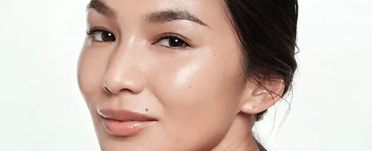 Rostro de mujer con piel radiante. Aprende cómo usar ácido glicólico para una piel luminosa y renovada.