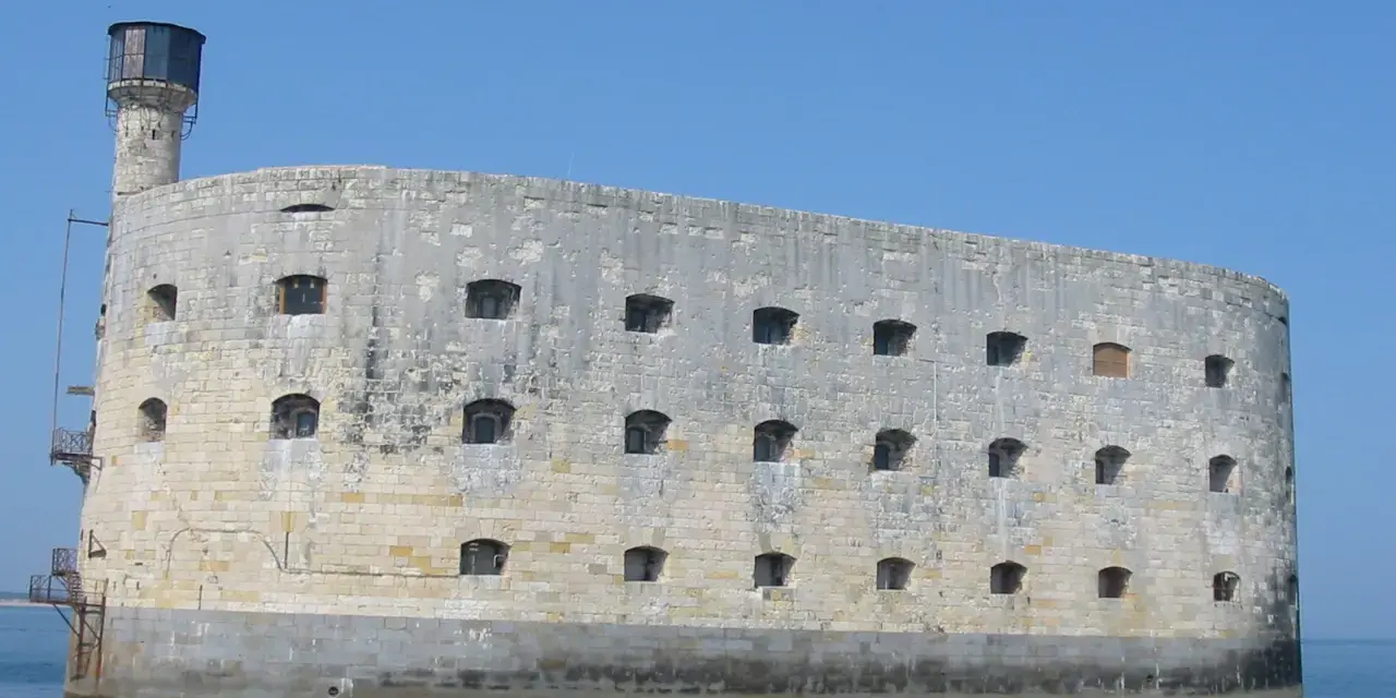 Fort Boyard, imponująca kamienna twierdza na wodzie, z licznymi oknami i wieżą.