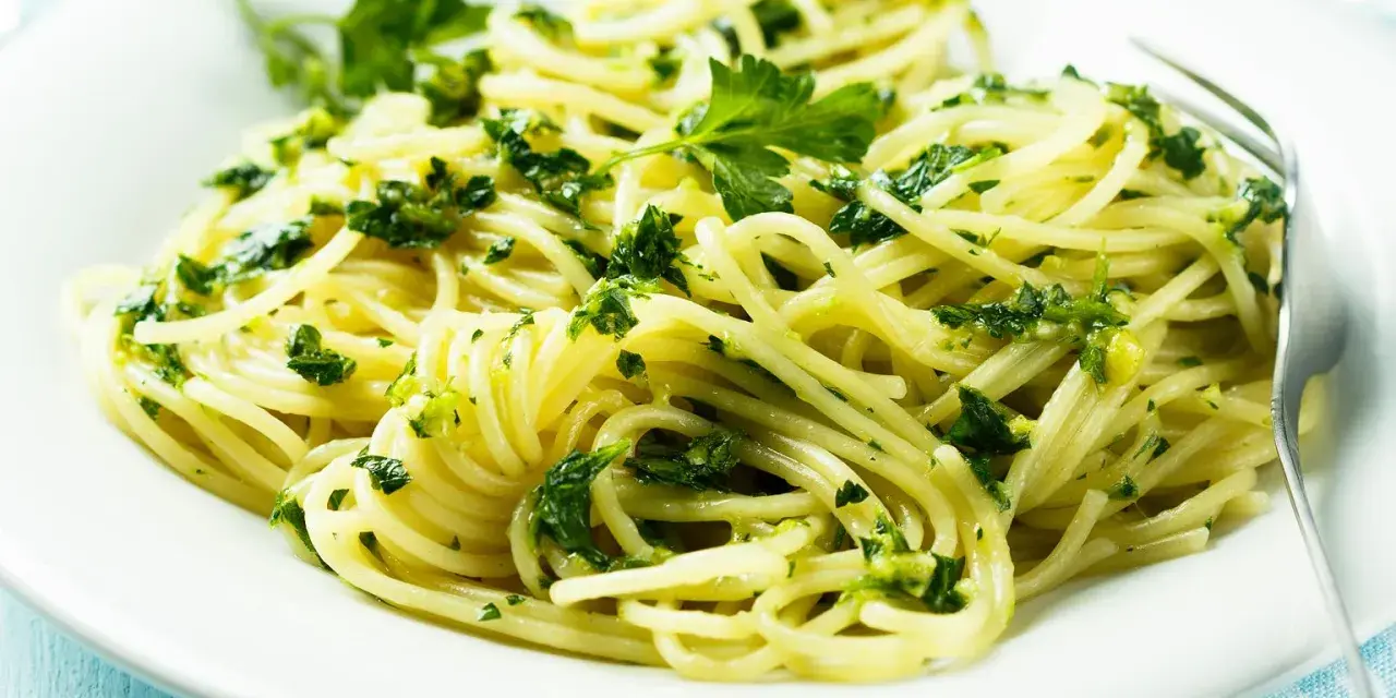 Pyszne spaghetti z zielonym pesto i świeżą natką pietruszki. Idealne na szybki obiad, inspiracja z przepisów z pesto.