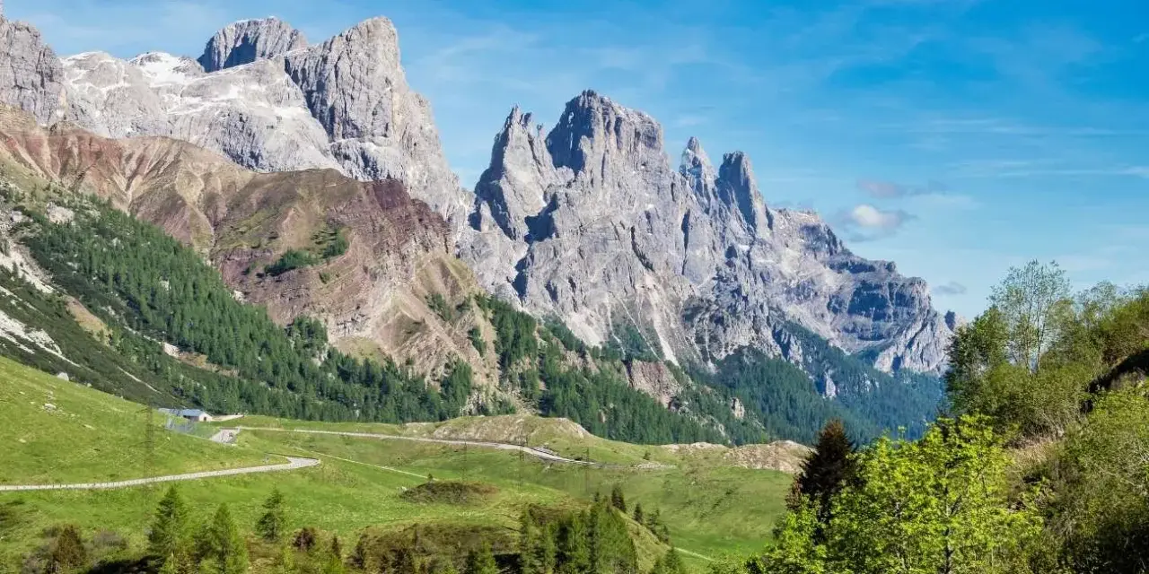 Panorami mozzafiato al Passo Rolle, con imponenti vette rocciose che si stagliano contro il cielo azzurro. L'altitudine regala un'aria pura e una vista indimenticabile.