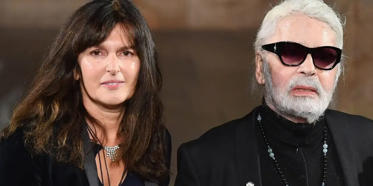 Karl Lagerfeld, iconico stilista Chanel, con una donna dai capelli scuri e un sorriso discreto.